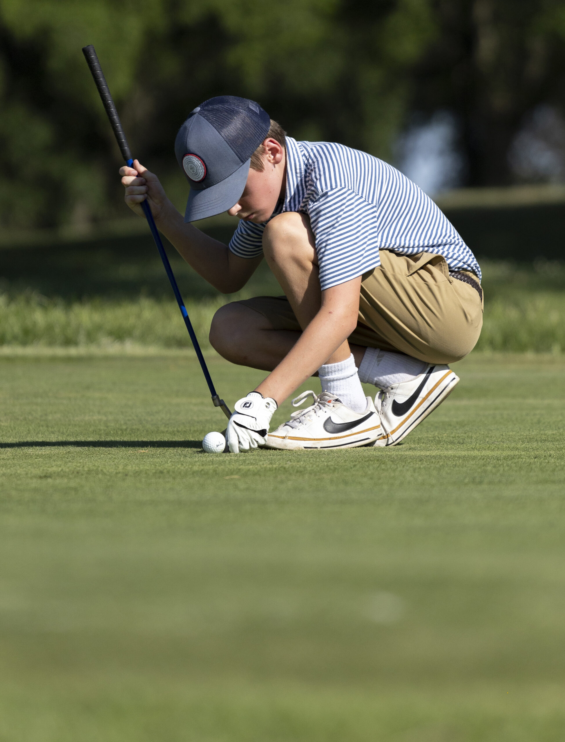 Junior golfer marks a putt